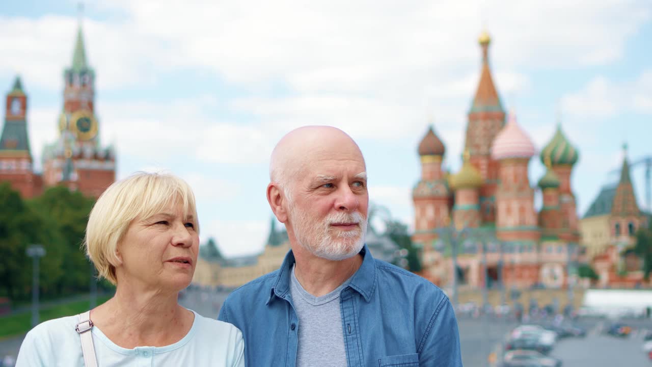 一对老年夫妇站在巴兹尔瀑布上环顾城市。在俄罗斯莫斯科旅行的退休人员视频下载