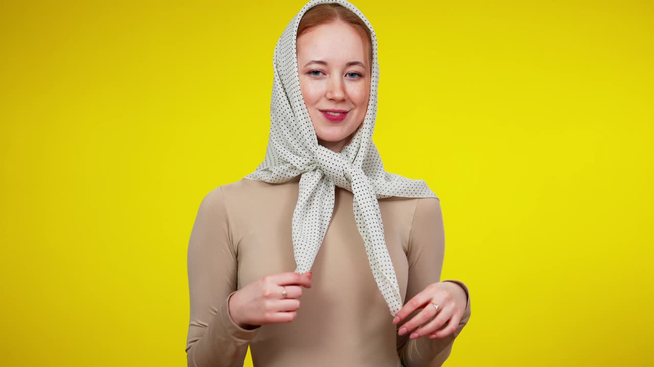 中景肖像苗条美丽的白人妇女取下头巾和擦拭额头。满头大汗的红发女士在黄色背景下摆姿势视频下载