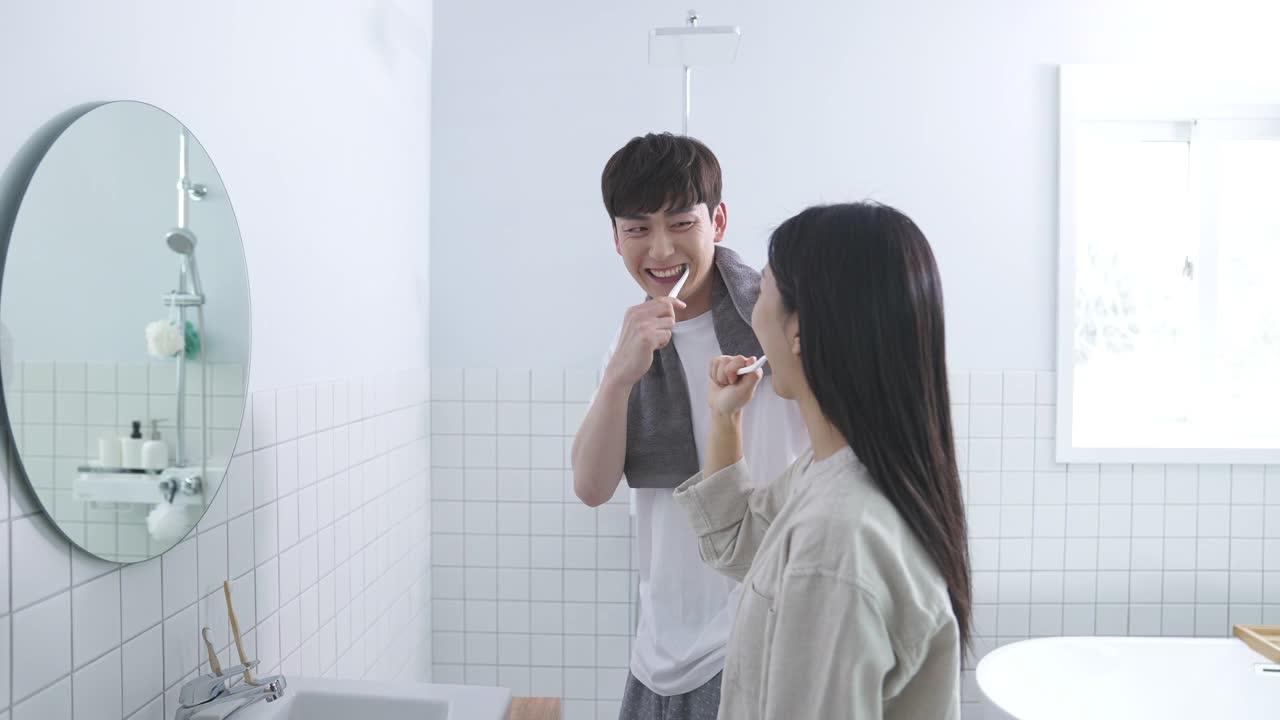 一对年轻男女在厕所里刷牙视频素材