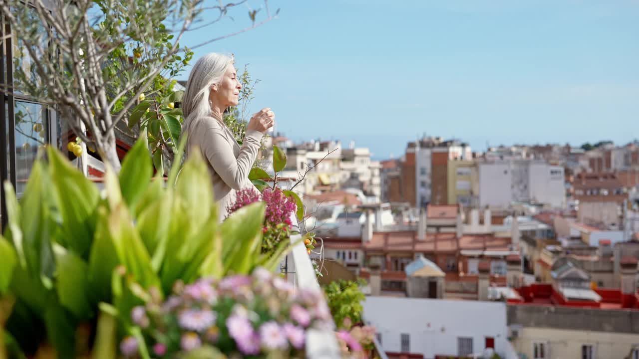 退休妇女从巴塞罗那公寓甲板欣赏风景视频素材