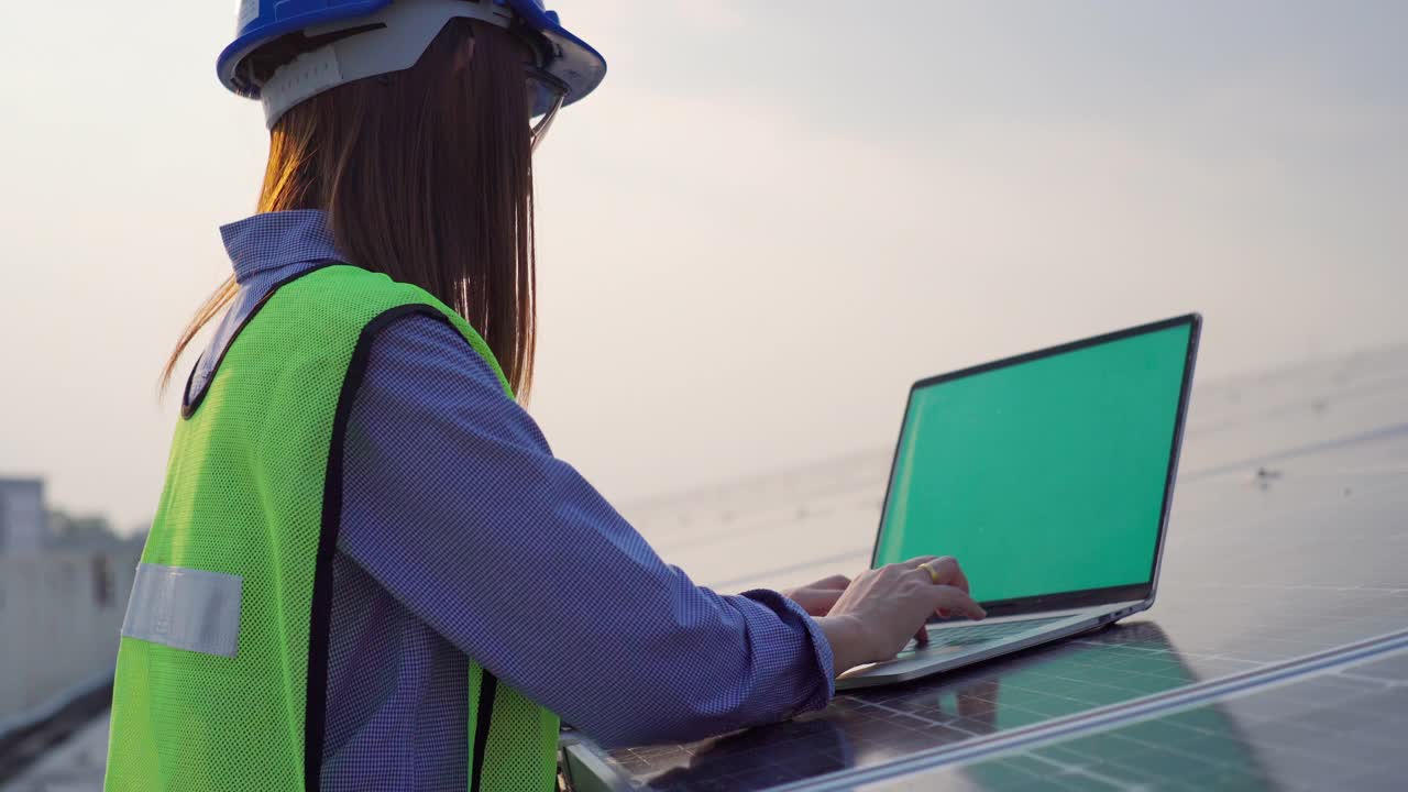 穿着制服的亚洲女工程师，在太阳能电池板厂用笔记本电脑工作视频素材