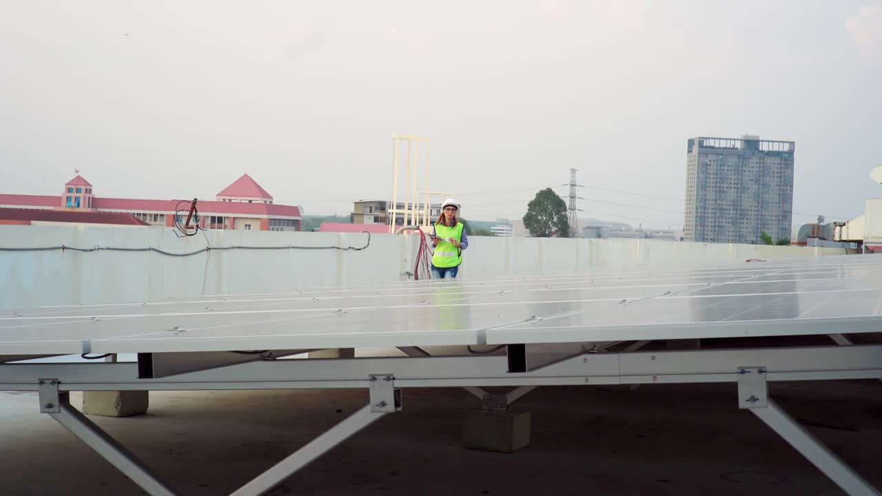 在太阳能电池板厂工作的亚洲女工程师视频素材