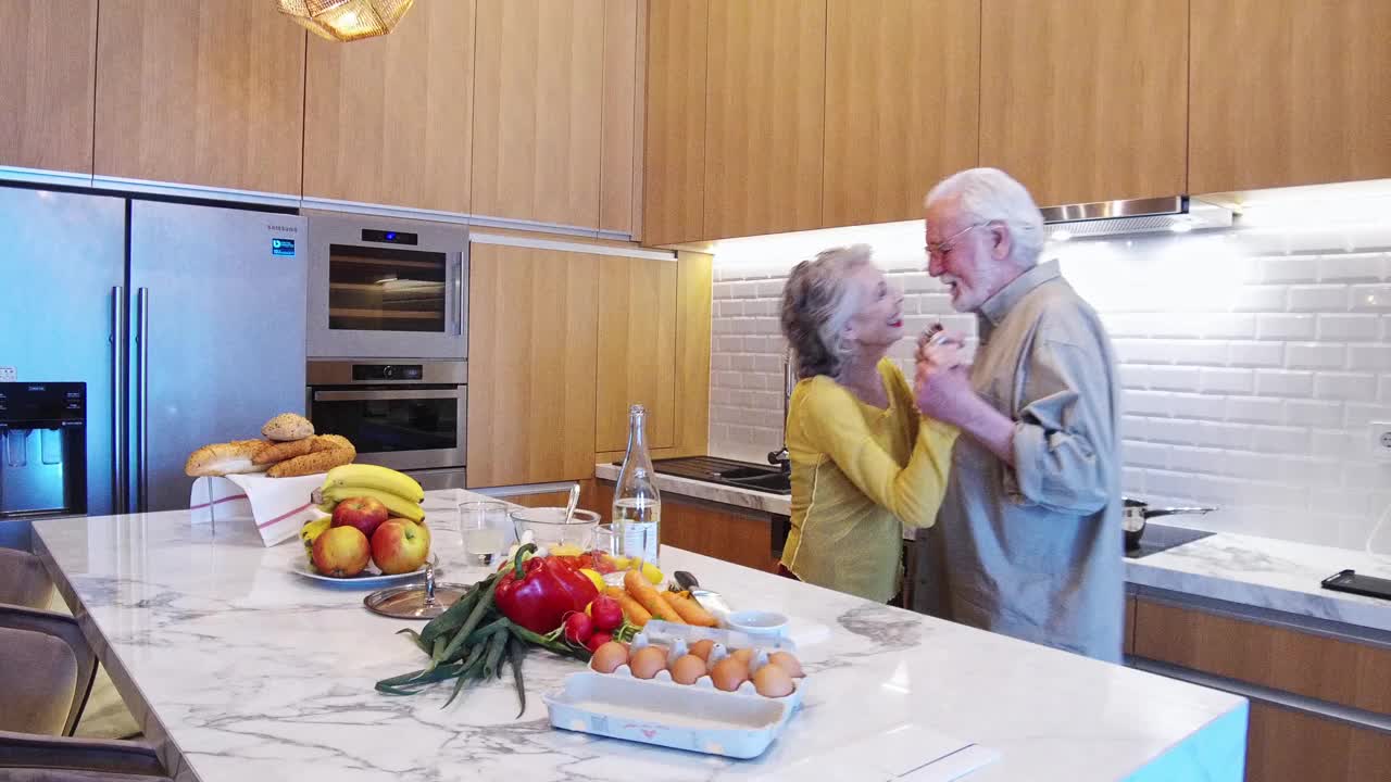 一对成熟的成年夫妇在厨房跳舞视频素材