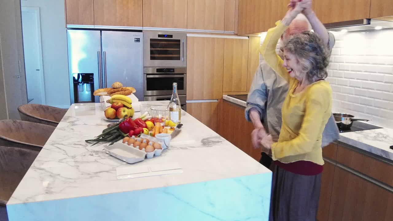 一对成熟的成年夫妇在厨房跳舞视频素材