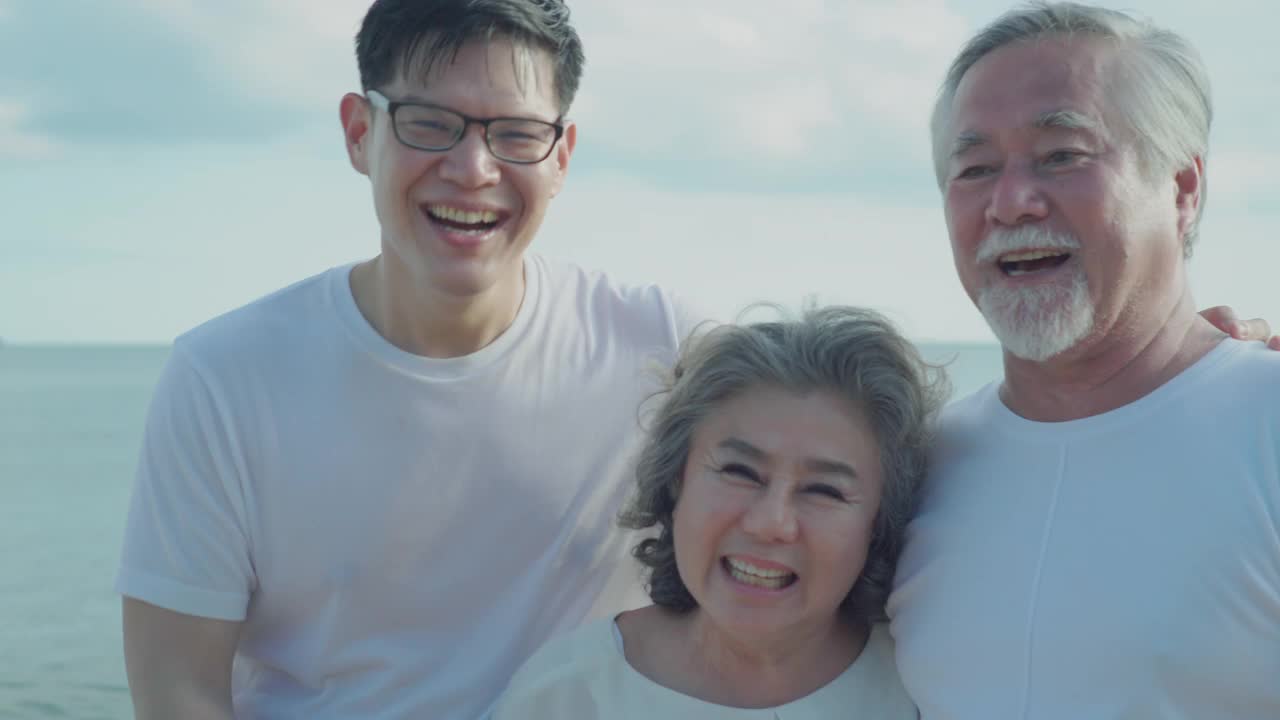 幸福的家庭，亚洲老年夫妇幸福的微笑和放松在海滩上。视频素材