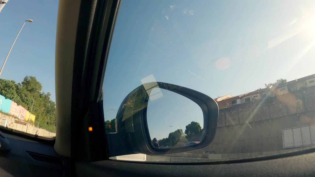 车侧后视镜的观点，在早上驾驶巡航在城市街道视频下载