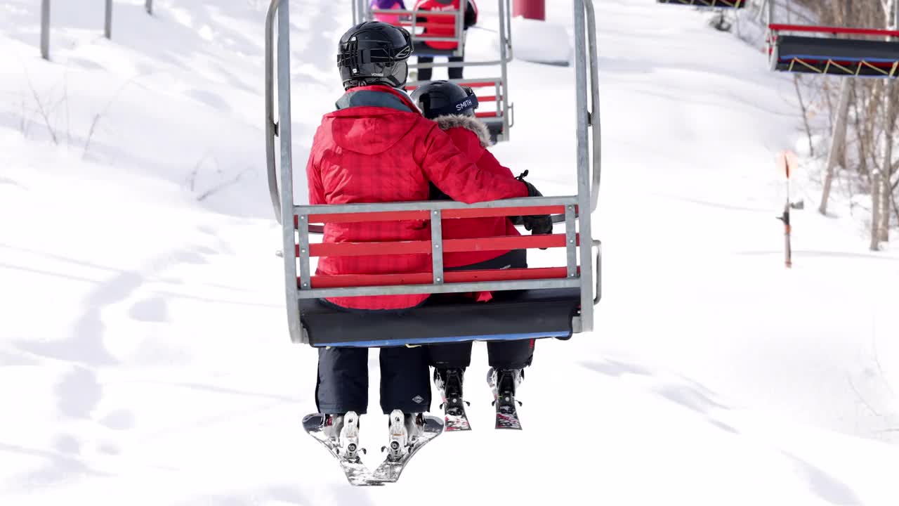 母亲和儿子在冬季滑雪缆车上视频素材