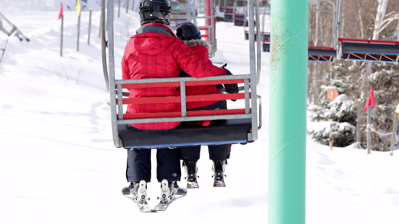 母亲和儿子在冬季滑雪缆车上视频素材