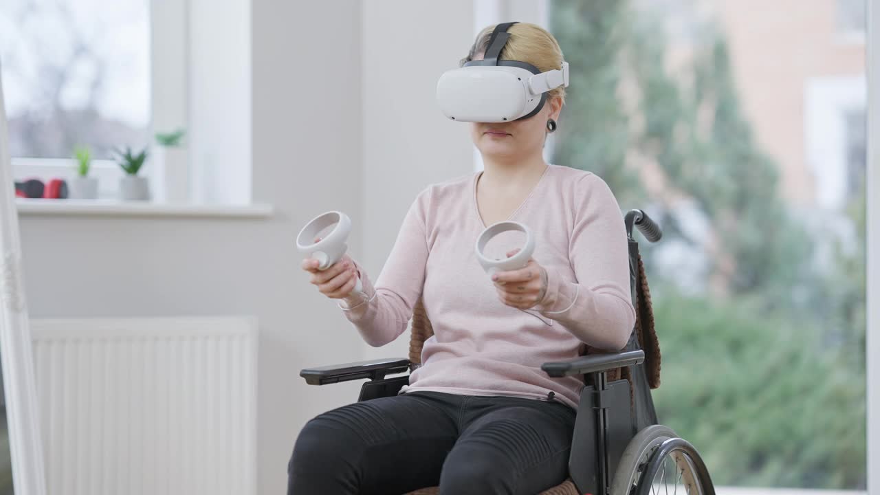 活跃的年轻截瘫妇女使用虚拟现实头盔坐在轮椅室内。正面的白人残疾人肖像使用VR头盔和运动控制器在线游戏。视频下载