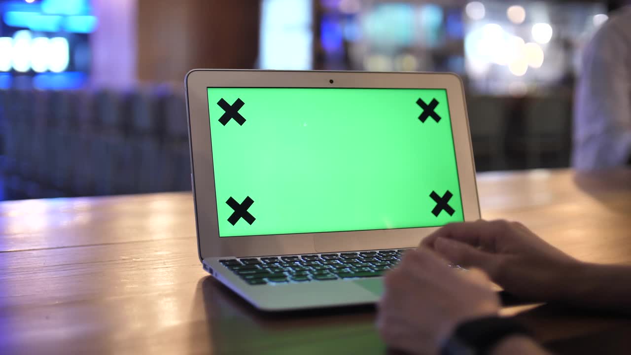 一位女士在笔记本电脑上使用绿屏模拟视频素材