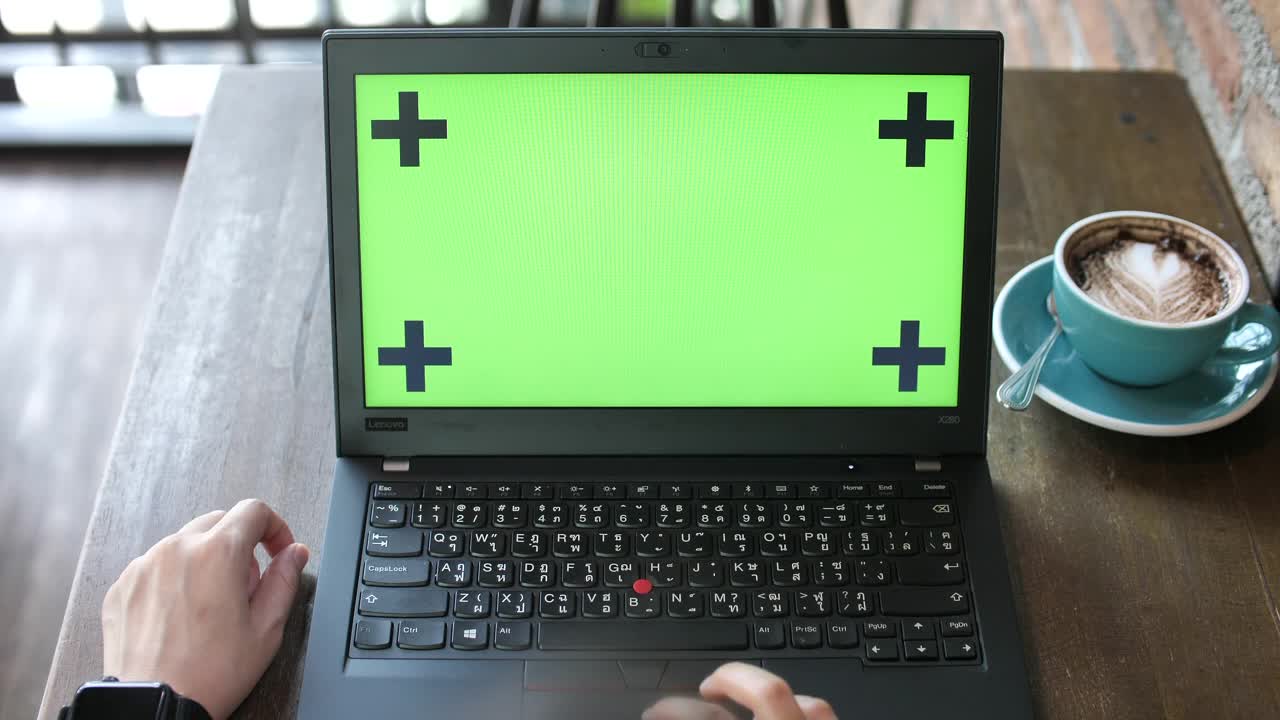双手在绿色屏幕上工作的笔记本电脑视频素材