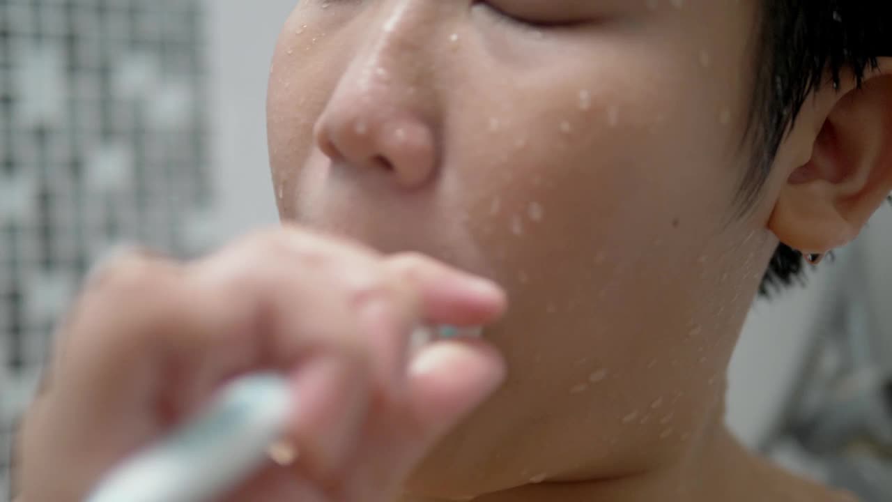 快乐的亚洲少年在家里的浴室刷牙，日常生活的概念。视频素材