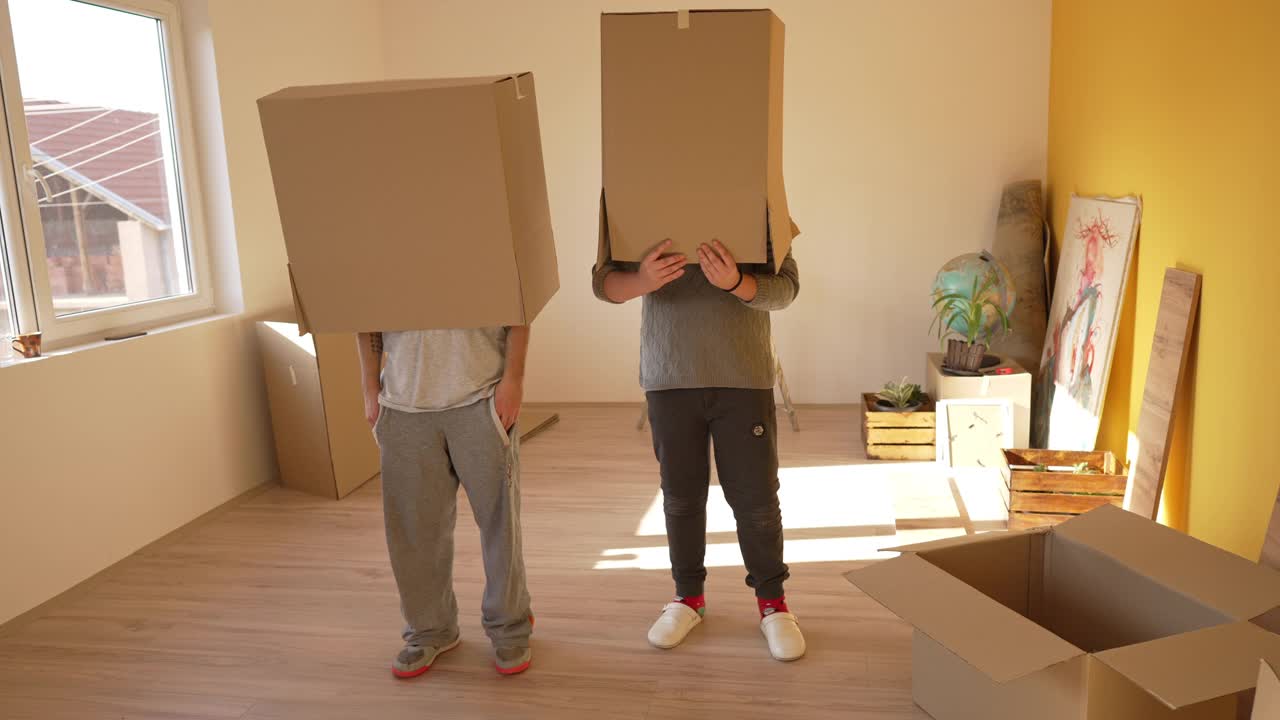 可爱的兄弟姐妹，刚搬进新公寓就在玩纸板箱视频素材