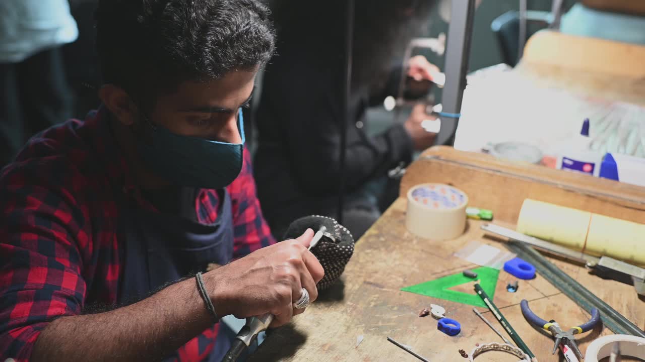 中东男学生在大学工作台擦拭珠宝视频素材