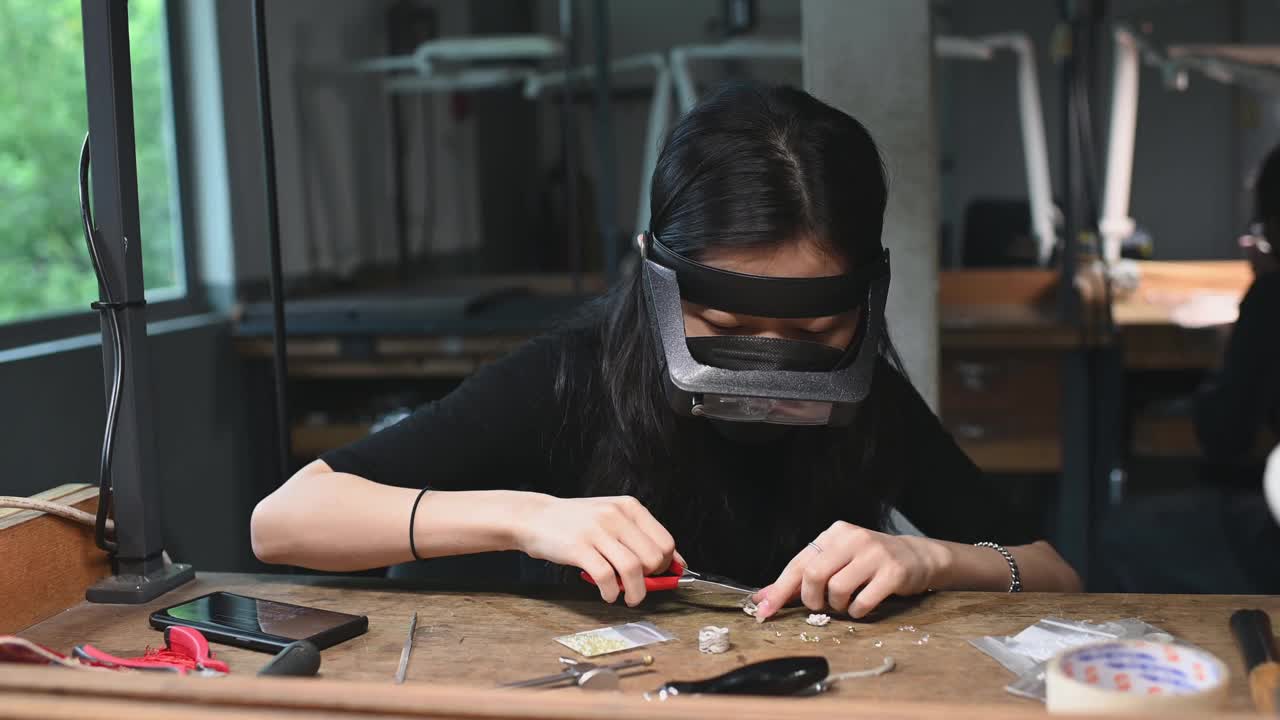 亚洲韩国女学生在大学工作台上用放大镜缝制珠宝视频下载
