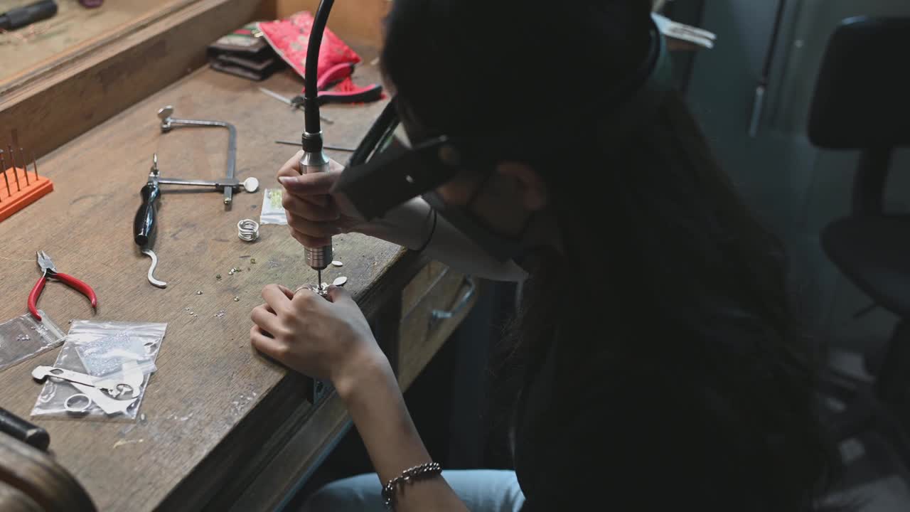 亚洲韩国女学生在大学工作台上用放大镜缝制珠宝视频素材