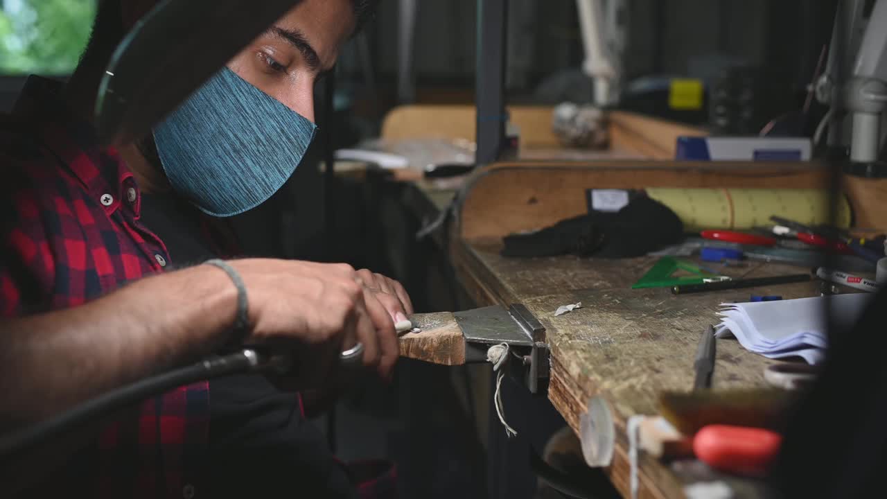 中东男学生在大学工作台擦拭珠宝视频素材