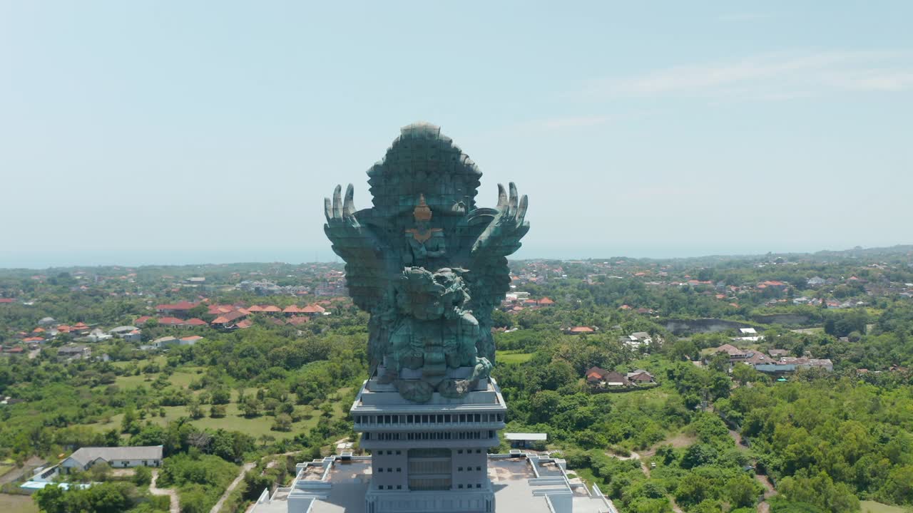 在印度尼西亚的巴厘岛，环绕着宏伟的Garuda Wisnu Kencana雕像。毗瑟奴骑着鹰路达的巨大宗教纪念碑雕塑在城市上空升起视频素材