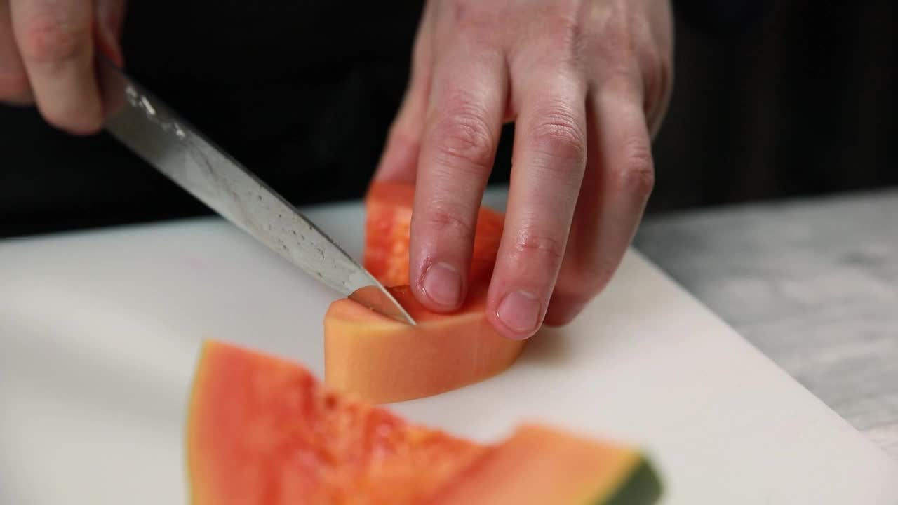 厨师在餐厅切木瓜。视频下载