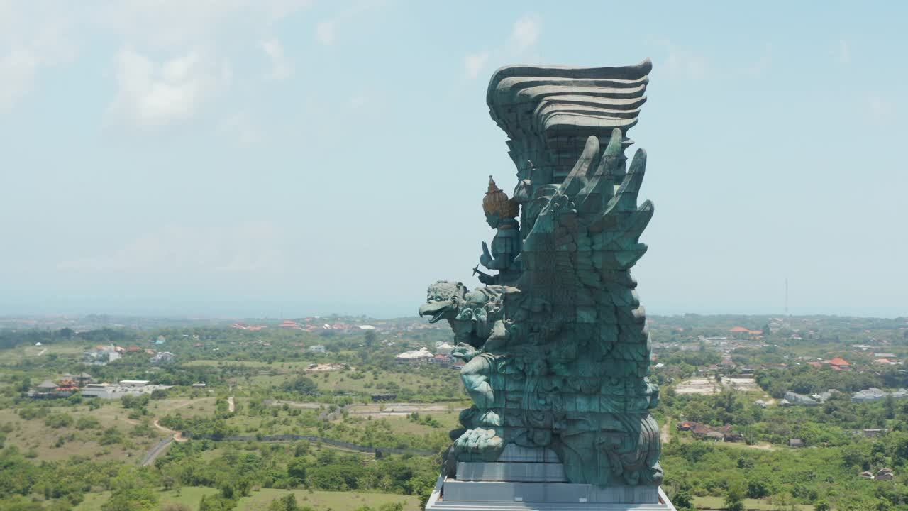 在印尼巴厘岛上空拍摄Garuda Wisnu Kencana雕像。著名的宗教雕像，背景是居民区视频素材