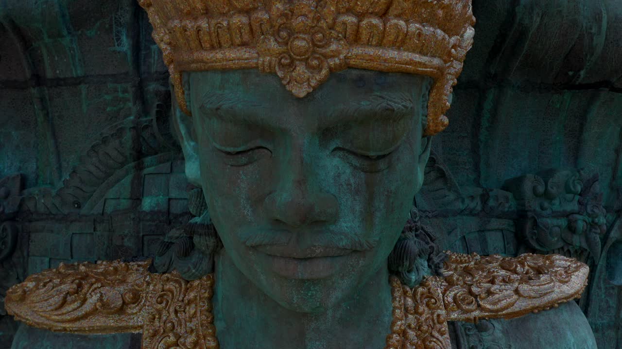 近距离观看Garuda Wisnu Kencana雕像在公园在印尼巴厘岛，上升的城市。空中撤退显示巨大的蓝色和绿色的印度宗教雕像视频素材