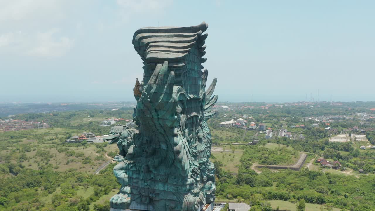 印尼巴厘岛巨大铜像的侧视图。Garuda Wisnu Kencana雕像在城市上空升起视频素材