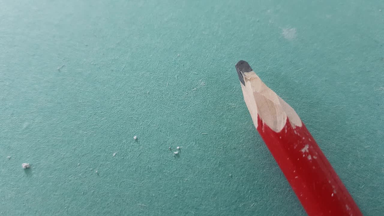 特写红色施工铅笔在绿色干墙。视频下载