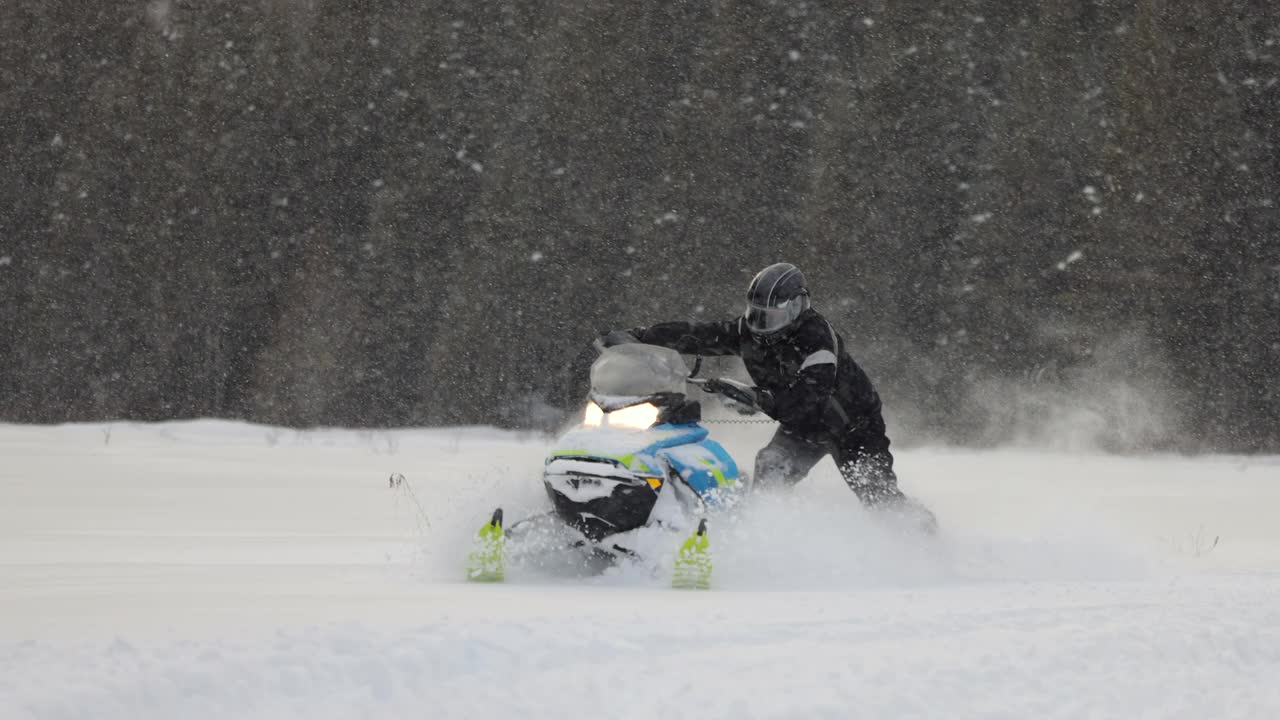 一个男人开着雪地摩托在粉末雪地里超速行驶的慢动作镜头视频下载