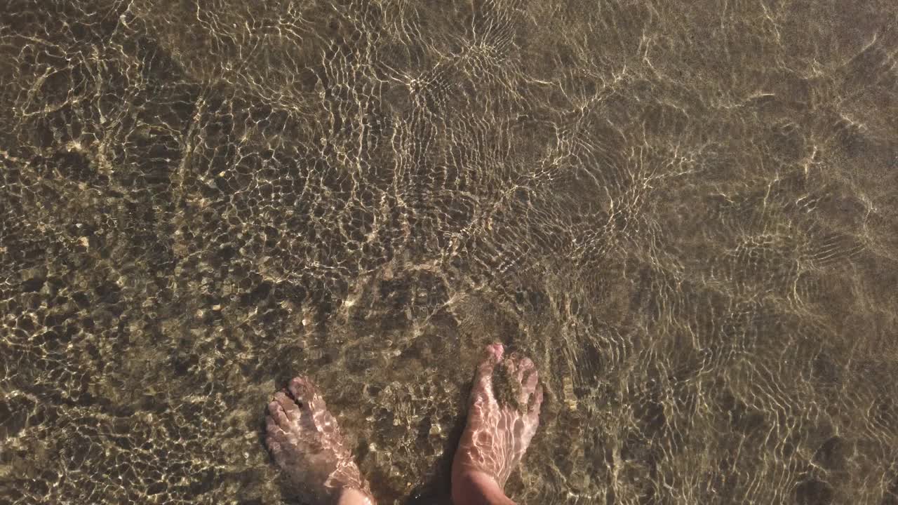俯视图的年轻人走在水晶海水上，夏天的生活方式，自由4k视频素材