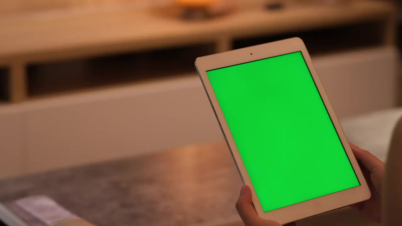 在家里用手触摸、点击和滚动绿色屏幕的平板电脑视频素材