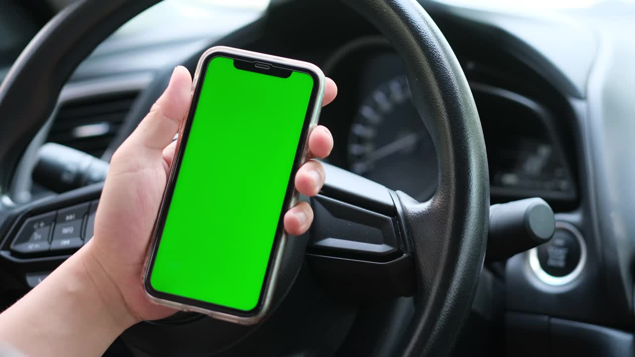 男人在车里滚动绿色屏幕的智能手机视频素材