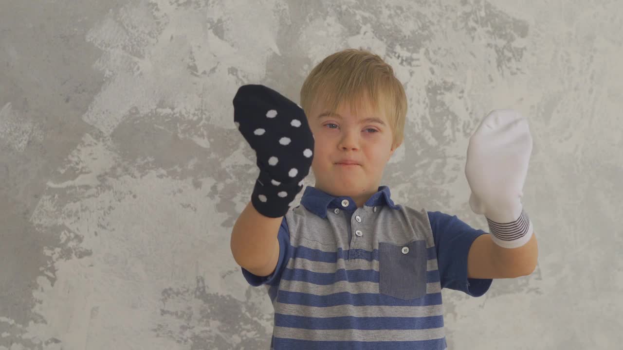患有唐氏综合症的小男孩喜欢把袜子套在手上视频素材