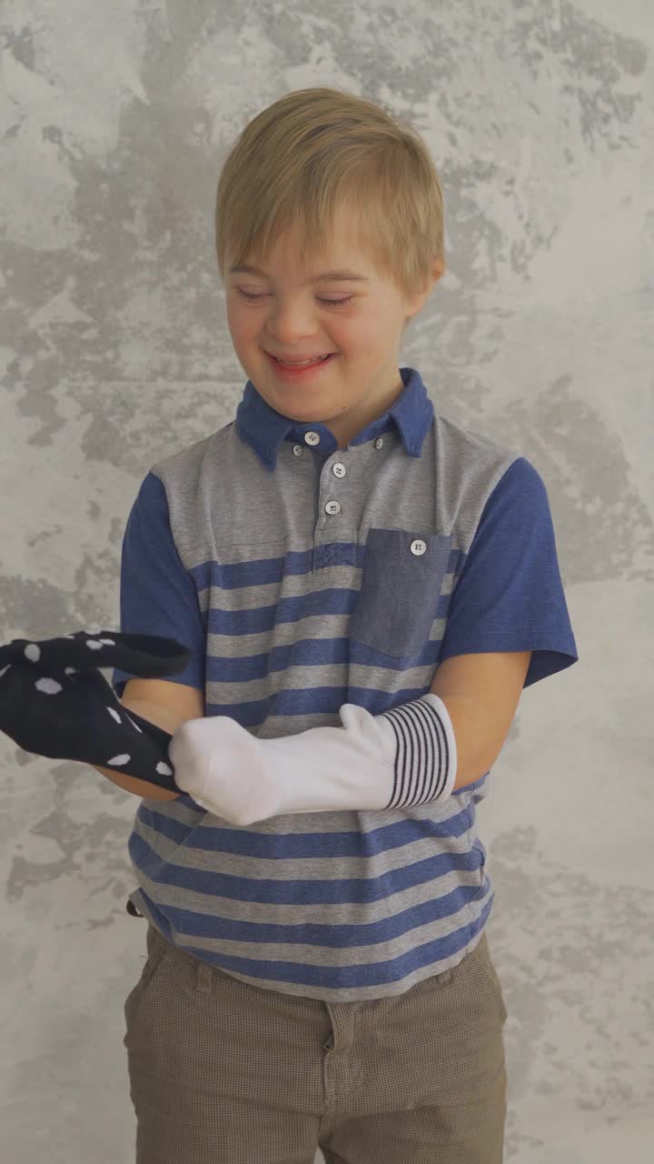 患有唐氏综合症的可爱小男孩喜欢袜子。垂直格式视频素材