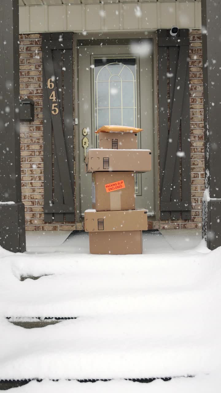 冬天暴风雪时，堆放在门外的快递盒子视频下载