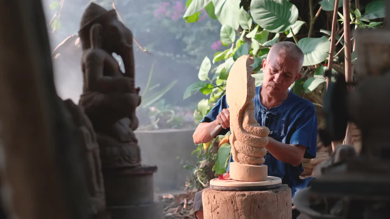 正面的亚洲石雕作品与雕塑看起来像古代风格和他坐在烟和线的阳光视频素材