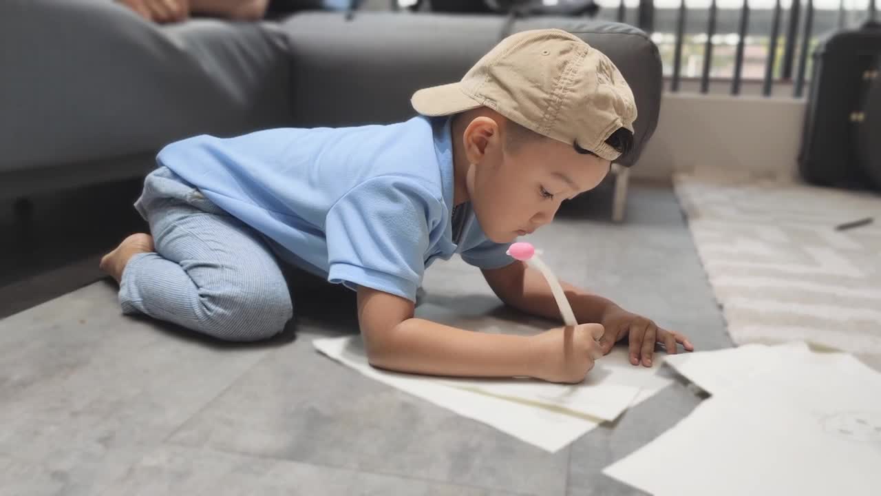 一个男孩在房子的地板上画画视频下载