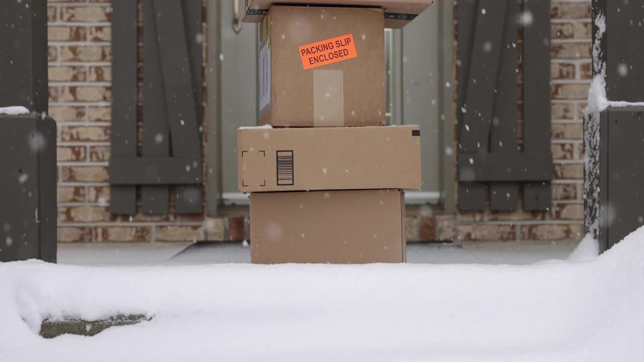 冬天暴风雪时，堆放在门外的快递盒子视频下载