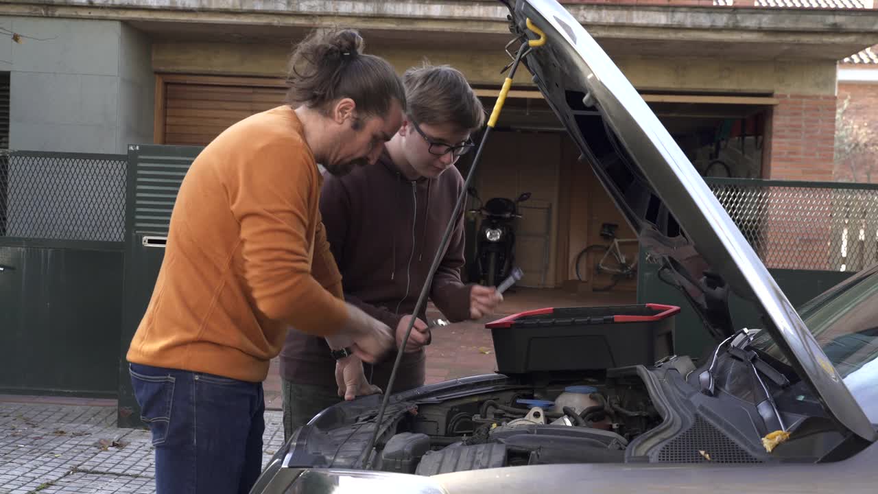 父亲教儿子如何修理汽车引擎。视频下载