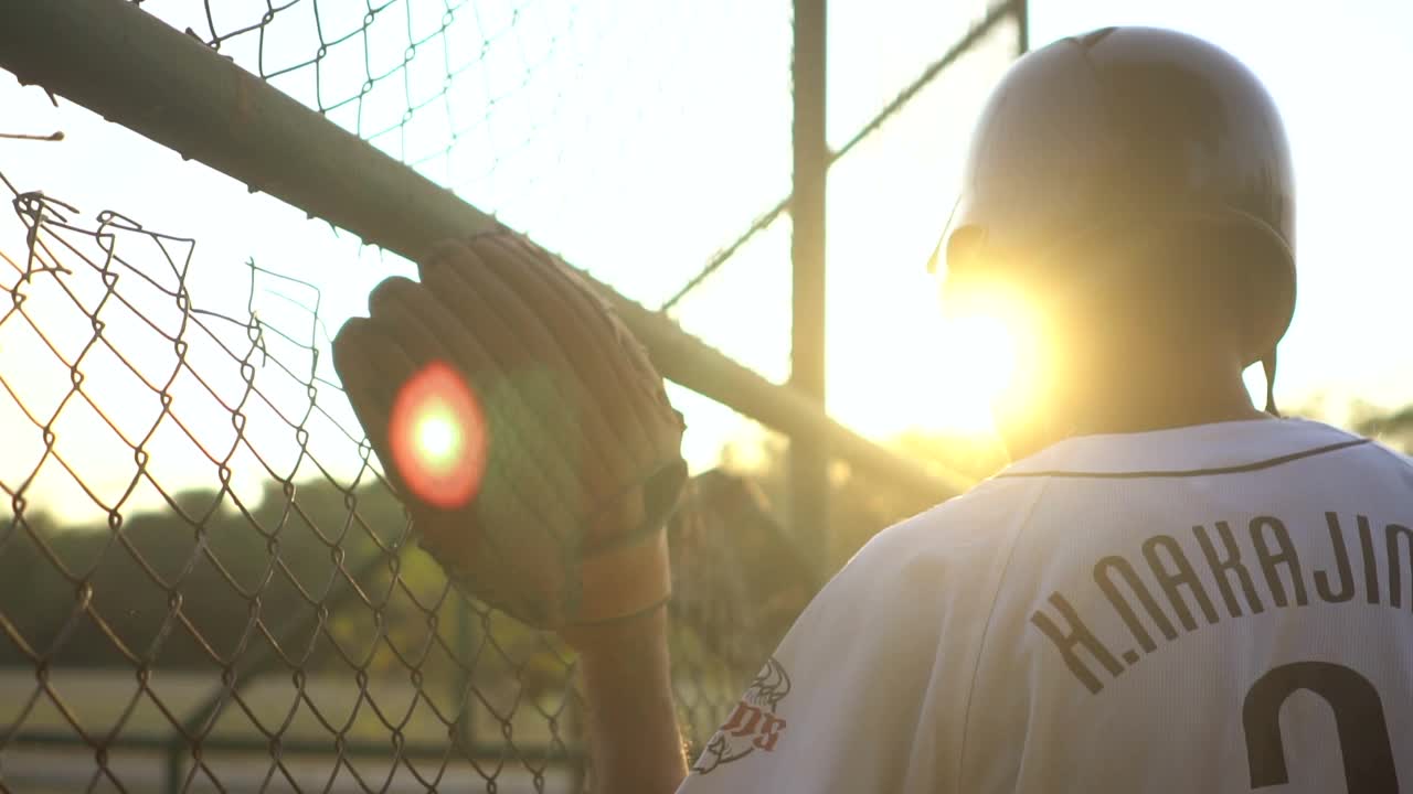 日落时分，棒球运动员在空旷的棒球场上练习击球视频下载