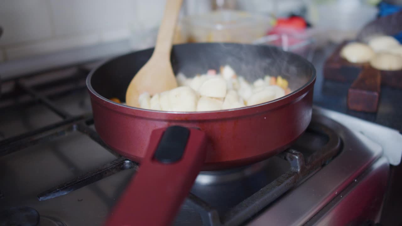 在厨房里，一个面目全非的女人正在切生土豆视频素材
