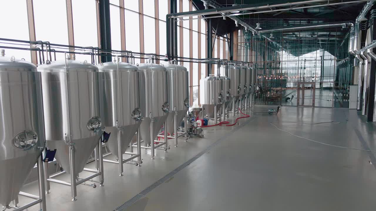 现代啤酒厂闪亮的金属啤酒罐。广角全景，摄像头正在移动视频下载