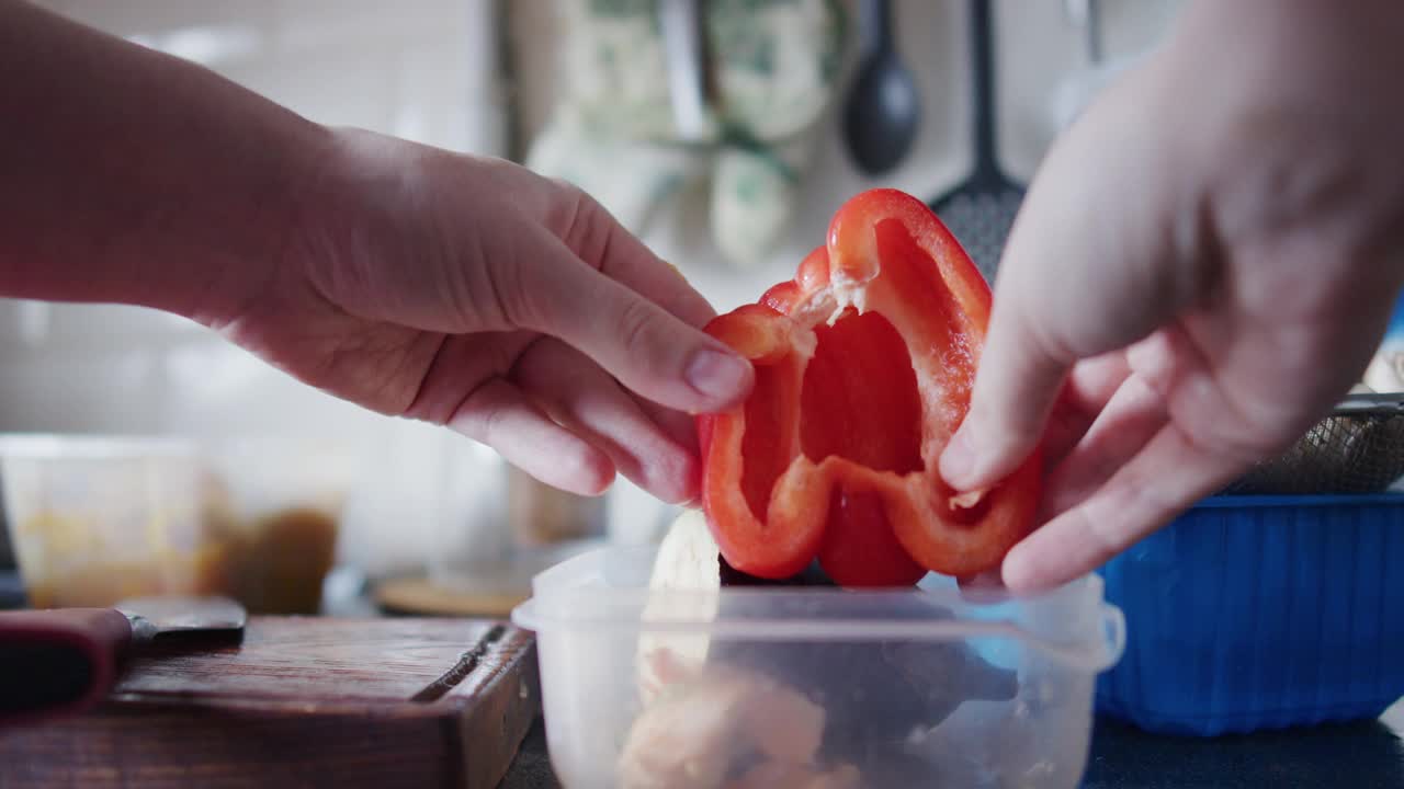 在家庭厨房里，一个面目全非的女人正在切红甜椒视频素材