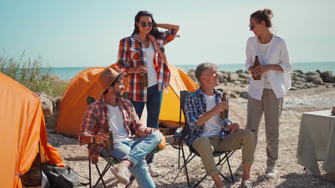 在海边的露营椅上，在帐篷里放松的群友旅行者视频下载