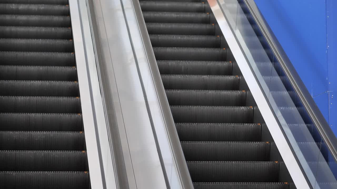 亚洲女性在机场的自动扶梯上走动视频下载