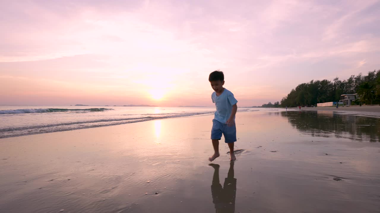 亚洲小孩在海滩上跑步。假期和健康的概念视频素材