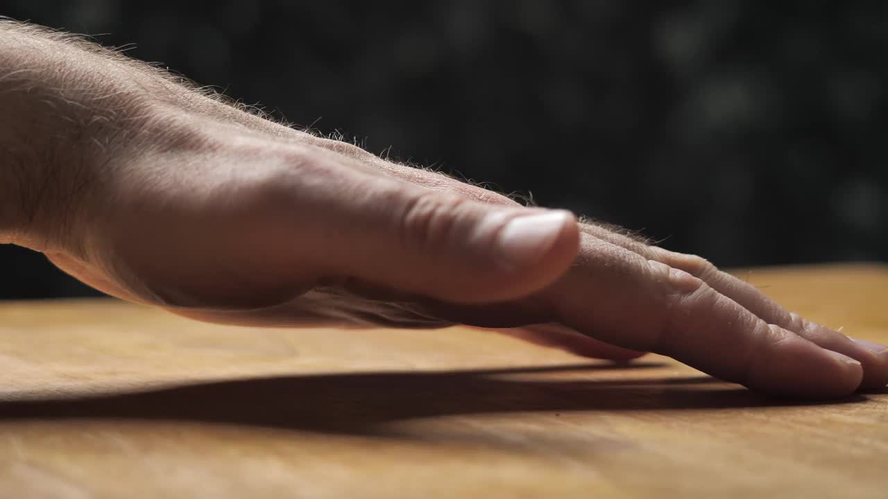 男性的手抚摸着一个涂了油的木制桌面。视频下载
