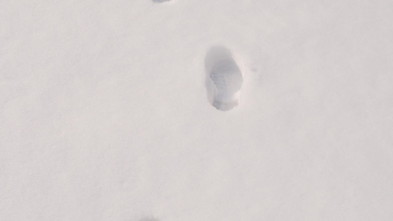 白雪上深深的脚印。后人类足迹视频下载
