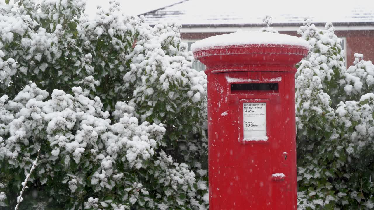 圣诞节飘落的雪花里的一个红色信箱视频素材