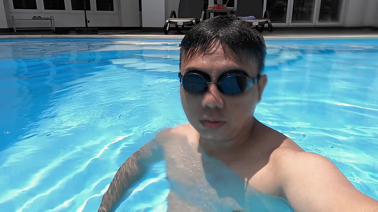 观点的亚洲华人男性看水下相机与游泳谷歌视频下载