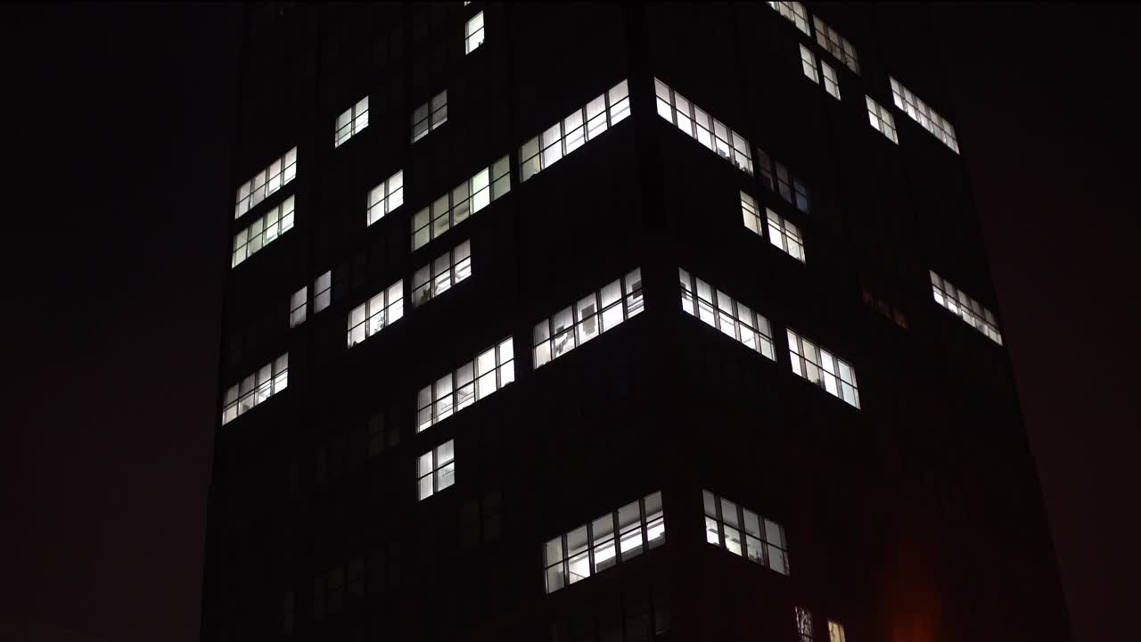 晚上的摩天大楼。所有的灯都熄灭了，时间流逝视频下载